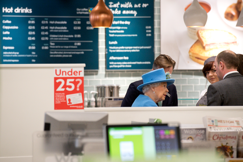 Britain’s Queen Elizabeth II (C) visits a Waitrose supermarket in the town on October 27, 2016 in Poundbury, England. Photo via Getty Images.